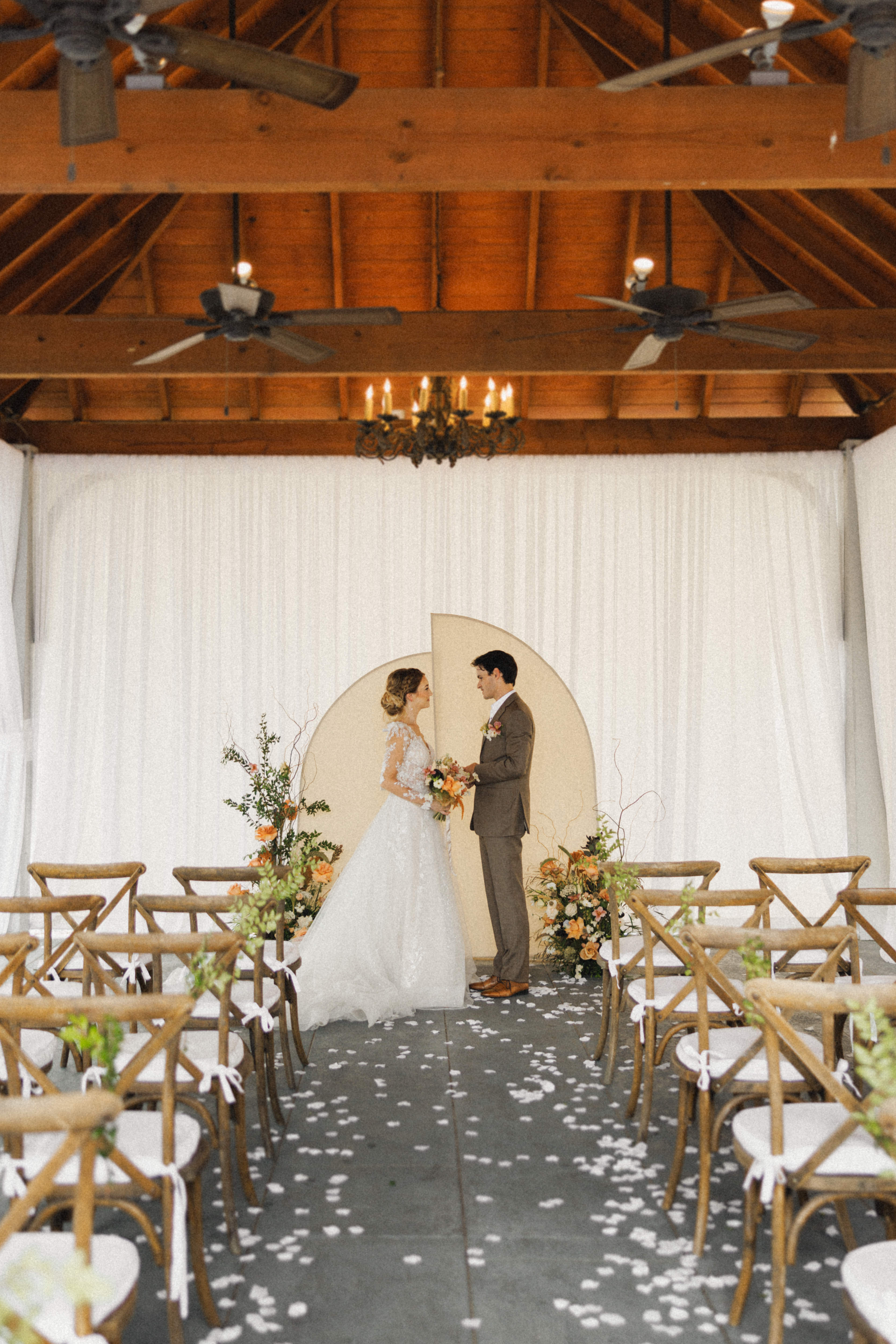 Bride and groom exchanging vows inside draped pavilion at Maison De Tours wedding venue Louisiana