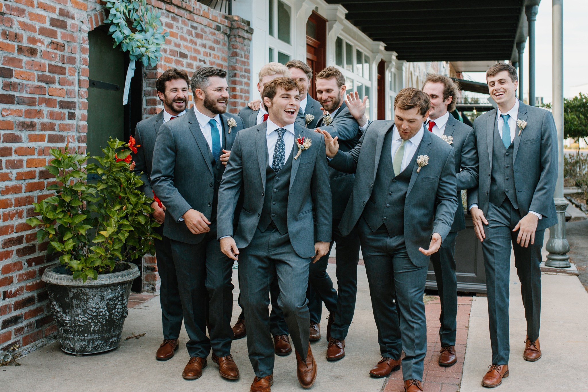 Groomsmen laughing outside Maison De Tours historic event venue Saint Martinville Louisiana
