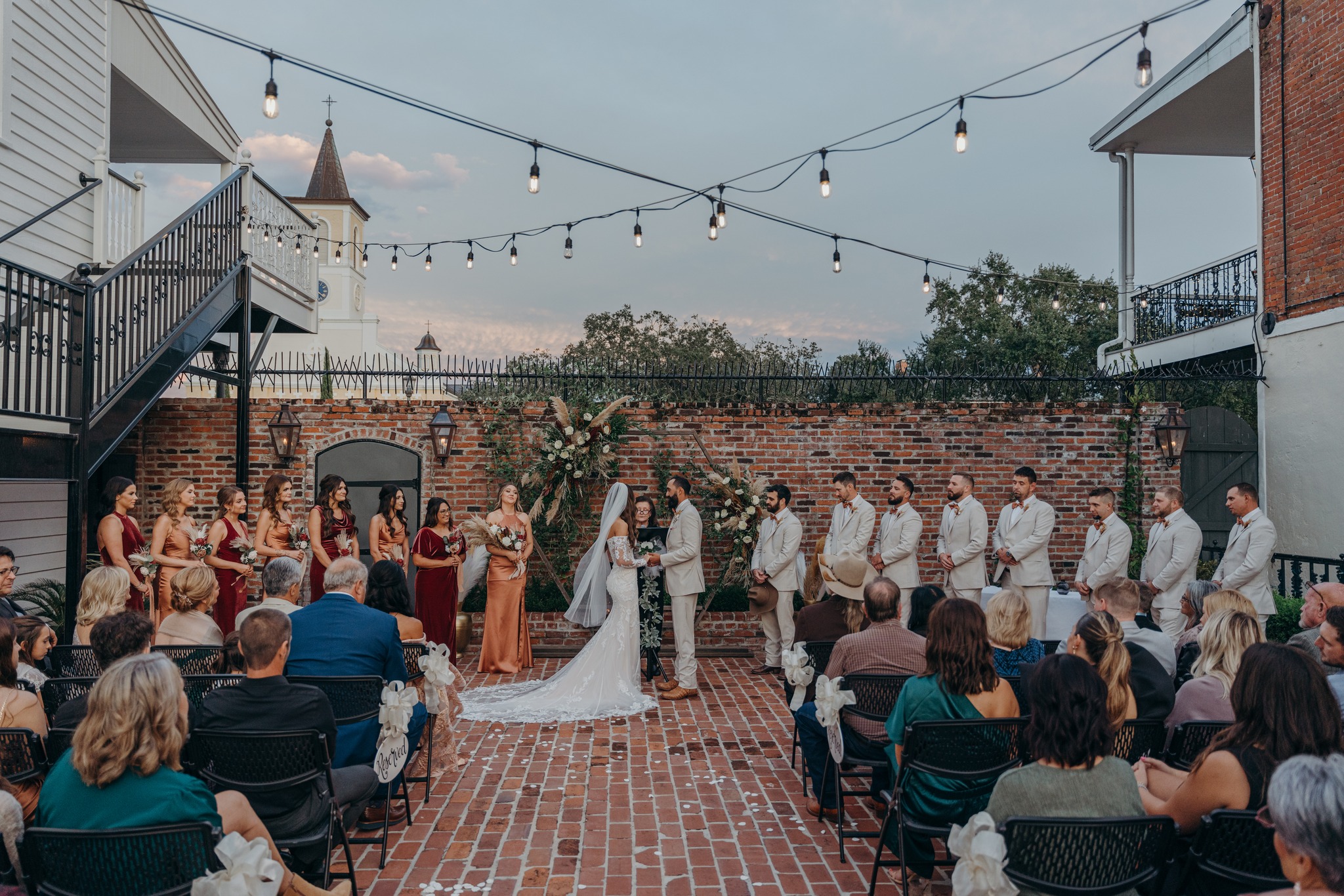 Outdoor wedding ceremony under string lights at Maison De Tours historic venue in Saint Martinville Louisiana