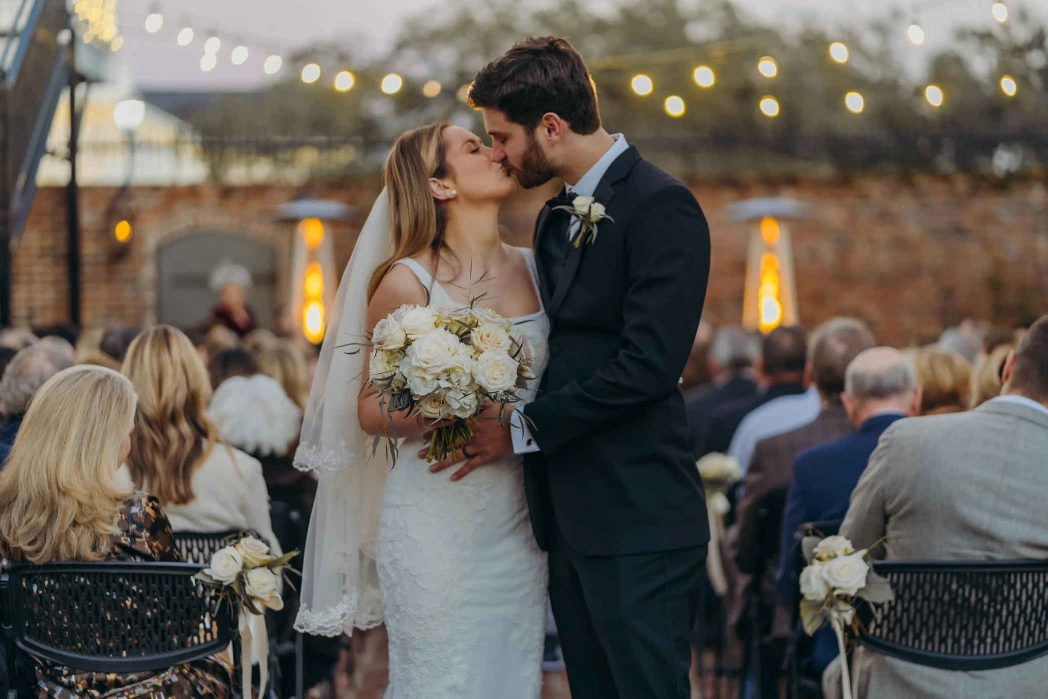 Bride and groom first kiss at outdoor wedding ceremony at Maison De Tours Saint Martinville Louisiana